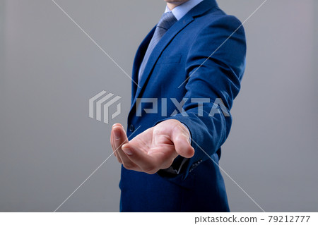 Midsection of caucasian businessman reaching his hand, isolated on grey background 79212777