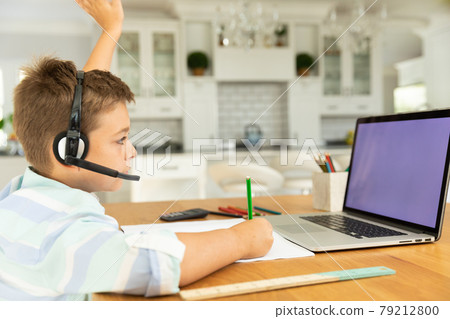 Caucasian boy using laptop with blank screen at home 79212800