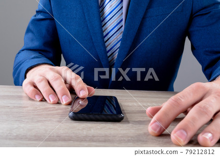 Midsection of caucasian businessman using smartphone, isolated on grey background 79212812