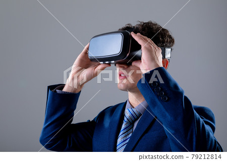 Caucasian businessman wearing vr headset, isolated on grey background 79212814