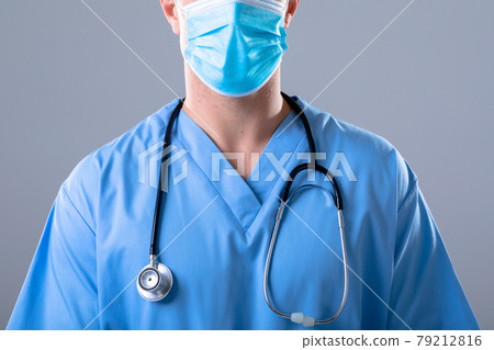 Caucasian male doctor wearing face mask, isolated on grey background 79212816