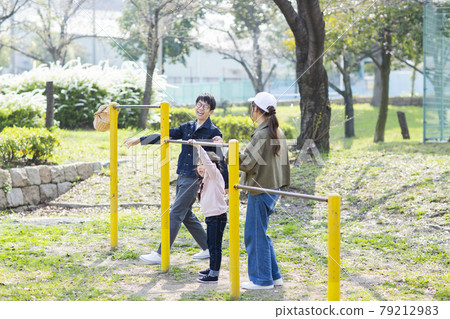 Parent and child playing in the park 79212983