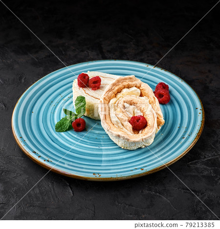 Meringue roll cake with cream and raspberries. Roulade, summer dessert, closeup. 79213385