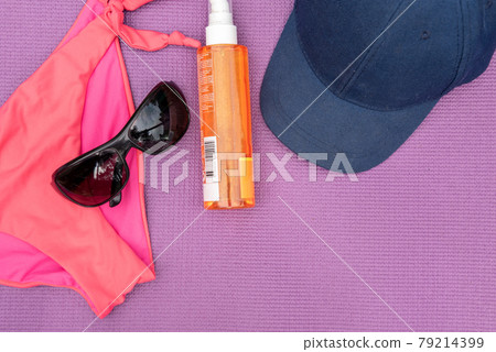 Top view of summer accessories on purple background 79214399