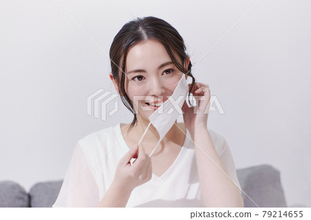 A smiling young woman who removes the mask 79214655