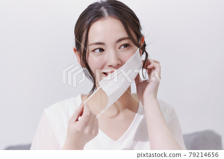 A smiling young woman who removes the mask 79214656