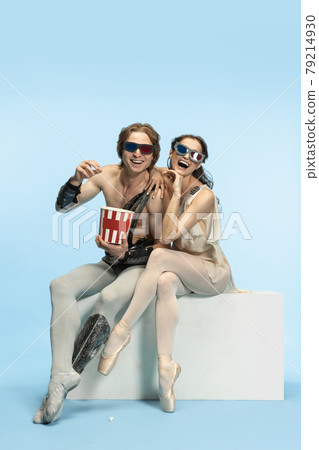 Movie lover. Young couple of ballet dancers in ancient Rome costums at blue studio. 79214930
