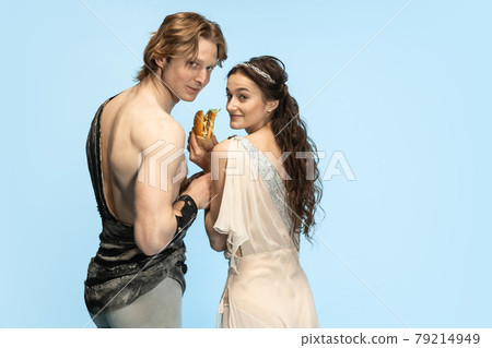 Burger and fast food. Young couple of ballet dancers in ancient Rome costums at blue studio. 79214949