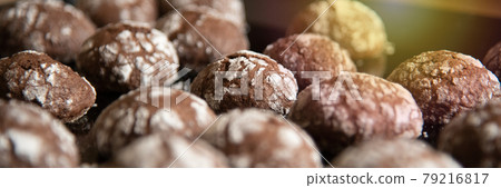 Cracked chocolate cookies with icing sugar on a pan 79216817