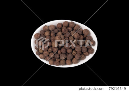 dried black peppercorns in ceramic bowl on black background 79216849