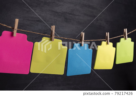 Multicolored blank paper cards hang with clothespin on rope. Copy space. Place for your text. 79217426