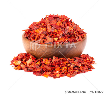 Dried red chili flakes in wooden bowl, isolated on white background. Chopped chilli cayenne pepper. Spices and herbs. 79218827