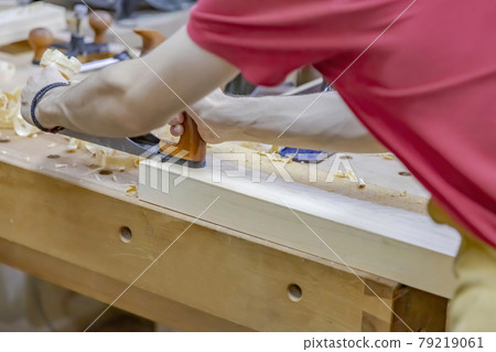 Worker's hands while working in a small carpentry workshop Worker's hands while working in a small carpentry workshop 79219061