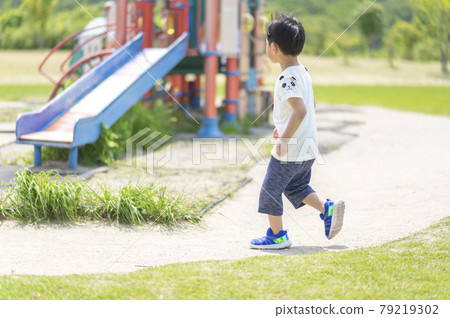 4-year-old boy running around the park 79219302