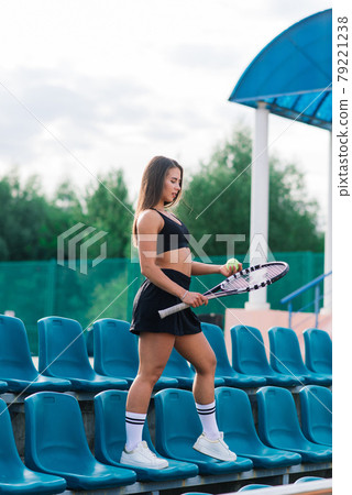 Beautiful stylish sexy woman in black trendy sportswear on tennis court. Beautiful stylish sexy woman in black trendy sportswear on tennis court. 79221238