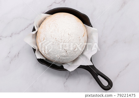 Fresh raw homemade yeast dough resting in cast iron skillet on marble table flat lay.. Fresh raw homemade yeast dough resting in cast iron skillet on marble table flat lay.. 79221475