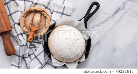Fresh raw homemade yeast dough resting in cast iron skillet on marble table flat lay. Fresh raw homemade yeast dough resting in cast iron skillet on marble table flat lay. 79221613