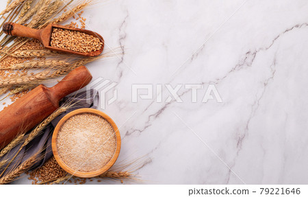 Wheat ears and wheat grains set up on marble background. Top view and copy space 79221646