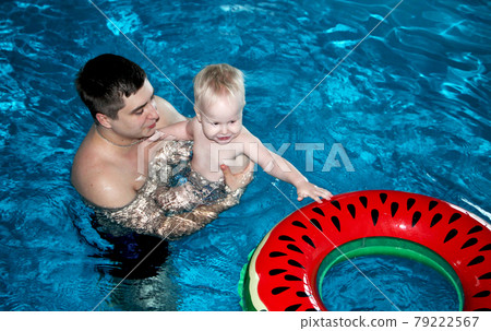 Father and son are swimming in the pool Father and son are swimming in the pool 79222567