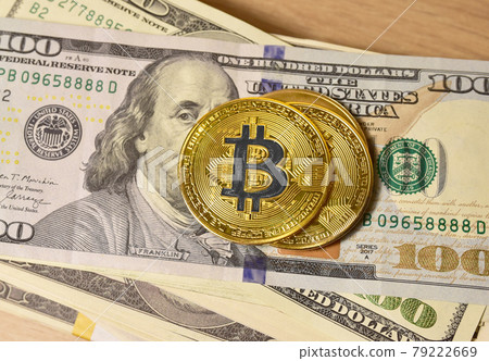 Bitcoin coins on a bundle with dollars.  79222669