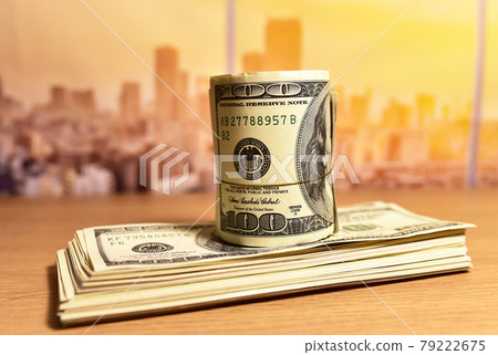 A bundle of one hundred dollar bills on table.  79222675