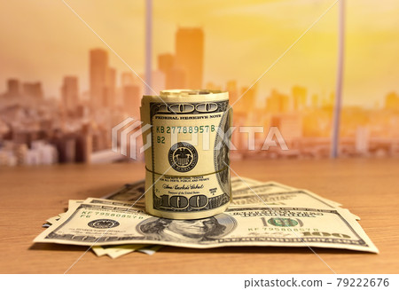 A bundle of one hundred dollar bills on table.  79222676