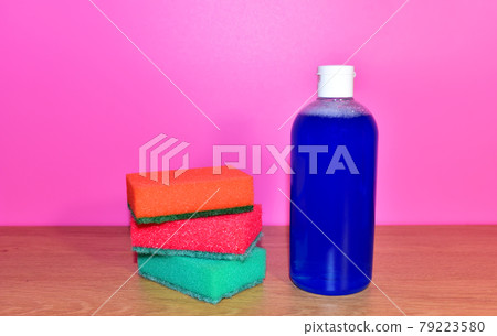 Detergent bottle and sponges on pink background. Detergent bottle and sponges on pink background. 79223580