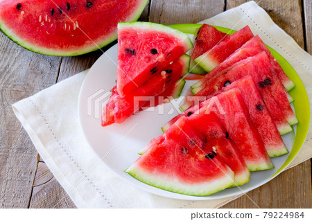 Fresh slices of watermelon on a wooden table. Fresh slices of watermelon on a wooden table. 79224984