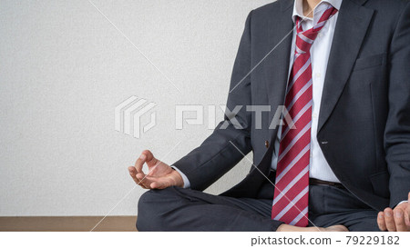 Loosen your tie and meditate at work. A refreshing businessman. A man doing yoga in a suit. Loosen your tie and meditate at work. A refreshing businessman. A man doing yoga in a suit. 79229182