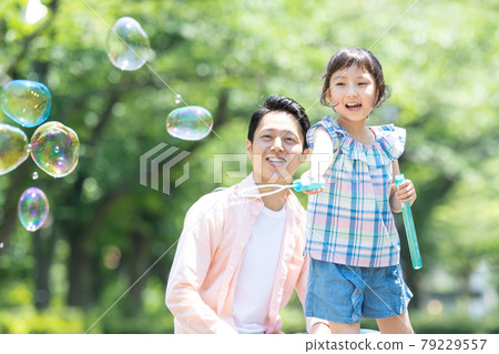 Parent-child park soap bubbles play 79229557