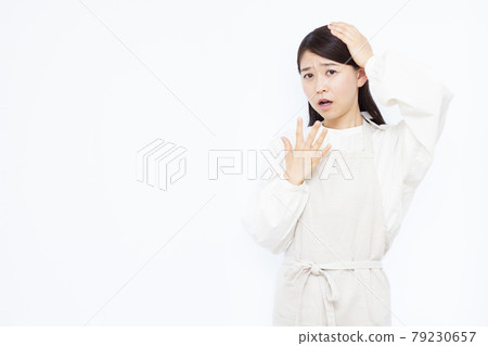一個三十多歲的家庭主婦驚訝地抱著她的頭 79230657