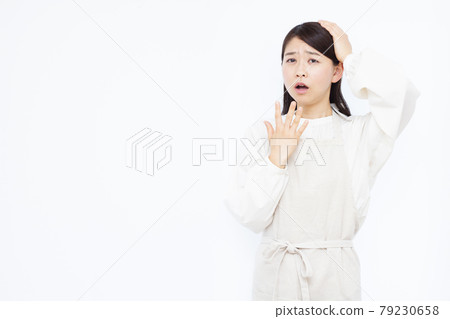 一個三十多歲的家庭主婦驚訝地抱著她的頭 79230658
