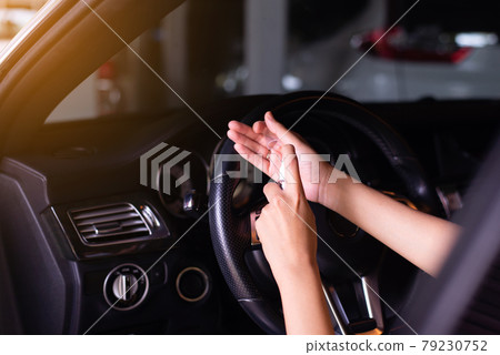 Woman using hand sanitizer spray before driving a car,Preventive measures against coronavirus,Covid-19 pandemic Woman using hand sanitizer spray before driving a car,Preventive measures against coronavirus,Covid-19 pandemic 79230752