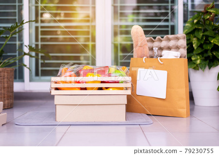 Delivery food service in wood box and paper bag for customer during corona virus or covid-19 spreading at front door home 79230755