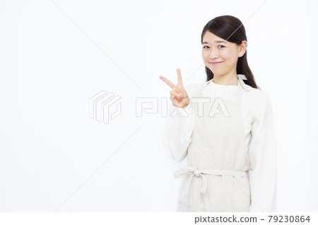 Housewife in her thirties doing a peace sign 79230864