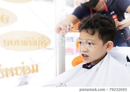 Cute asian child boy getting hair cut by hairdresser at hair salon. Hair care and childhood lifestyle concept. Cute asian child boy getting hair cut by hairdresser at hair salon. Hair care and childhood lifestyle concept. 79232693