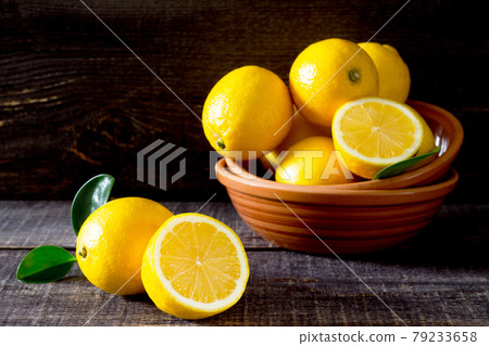 Fresh lemons in a bowl on a wooden table Fresh lemons in a bowl on a wooden table 79233658