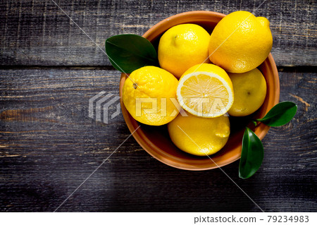 Fresh lemons in a bowl on the table, space for text. Fresh lemons in a bowl on the table, space for text. 79234983