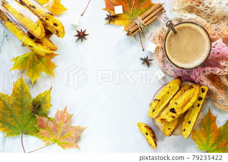 Freshly baked raisins and cinnamon biscotti and a cup of cappuccino coffee on a gray slate or slate background. Top view with copy space. Freshly baked raisins and cinnamon biscotti and a cup of cappuccino coffee on a gray slate or slate background. Top view with copy space. 79235422