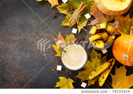 Freshly baked raisins and cinnamon biscotti and a cup of cappuccino coffee on a brown slate or slate background. Top view with copy space. Freshly baked raisins and cinnamon biscotti and a cup of cappuccino coffee on a brown slate or slate background. Top view with copy space. 79235424