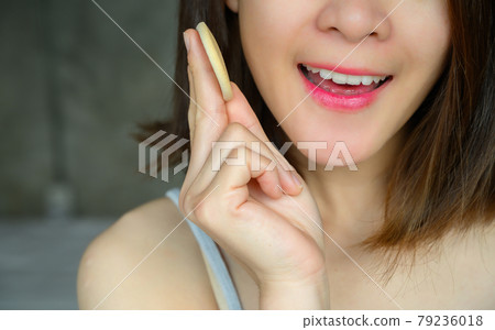 Cropped shot of young attractive Asian woman applying foundation powder puff on her face to cover flaws and change the natural skintone. Conceptual of women's beauty and cosmetic. 79236018