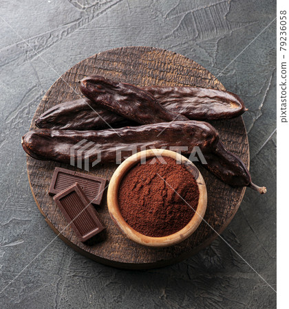 Carob pod and carob powder on white backgrounds. 79236058
