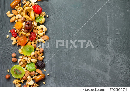 Various dried fruits and mix nuts on a gray stone or slate background. The concept of the Jewish holiday Tu Bishvat. Flat lay, top view with copy space. Various dried fruits and mix nuts on a gray stone or slate background. The concept of the Jewish holiday Tu Bishvat. Flat lay, top view with copy space. 79236974
