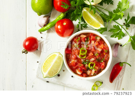 Traditional mexican homemade salsa sauce and ingredients on a white wooden table. Top view on a flat background. Copy space. Traditional mexican homemade salsa sauce and ingredients on a white wooden table. Top view on a flat background. Copy space. 79237923