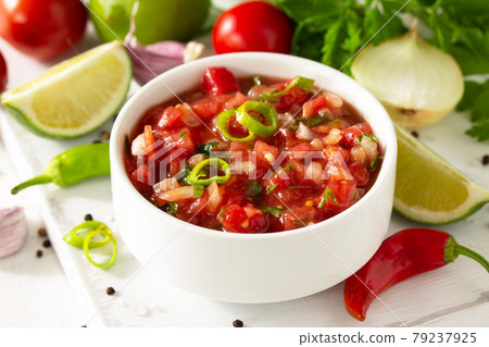 Traditional mexican homemade salsa sauce and ingredients on a white wooden table. 79237925