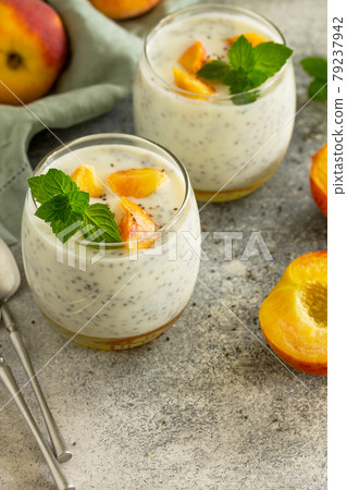 Natural detox, fruit dessert, healthy dieting concept. Peach Yogurt smoothie or milk shake with chia seeds in glass jar on a stone concrete worktop. Copy space. Natural detox, fruit dessert, healthy dieting concept. Peach Yogurt smoothie or milk shake with chia seeds in glass jar on a stone concrete worktop. Copy space. 79237942