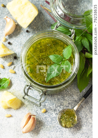 Healthy Italian cuisine. Green pesto sauce isolated on a stone countertop made of light concrete. 79238635