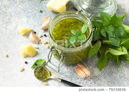 Healthy Italian cuisine. Green pesto sauce isolated on a stone countertop made of light concrete. 79238636