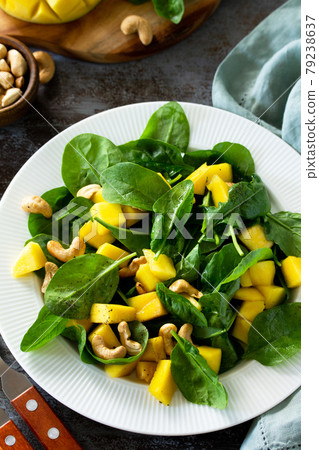 Diet menu, Vegan food concept. Healthy salad with mango, spinach, pecan and vinaigrette dressing on a stone table. Diet menu, Vegan food concept. Healthy salad with mango, spinach, pecan and vinaigrette dressing on a stone table. 79238637