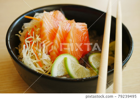 Portioned raw salmon fillets in ice with lemon. 79239495
